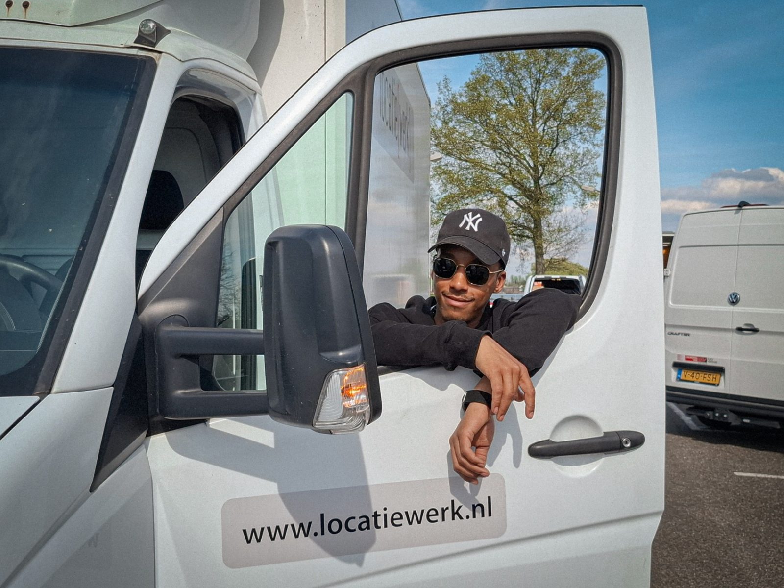 Issam smiling in the cab of a van