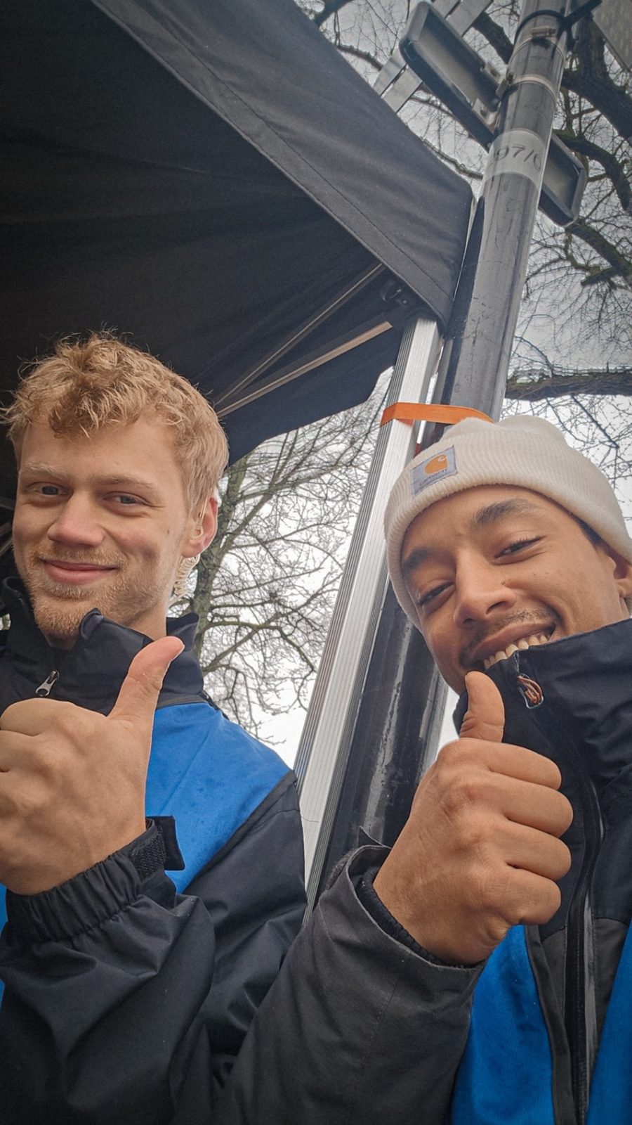 Issam and a colleague giving a thumbs up by the tent