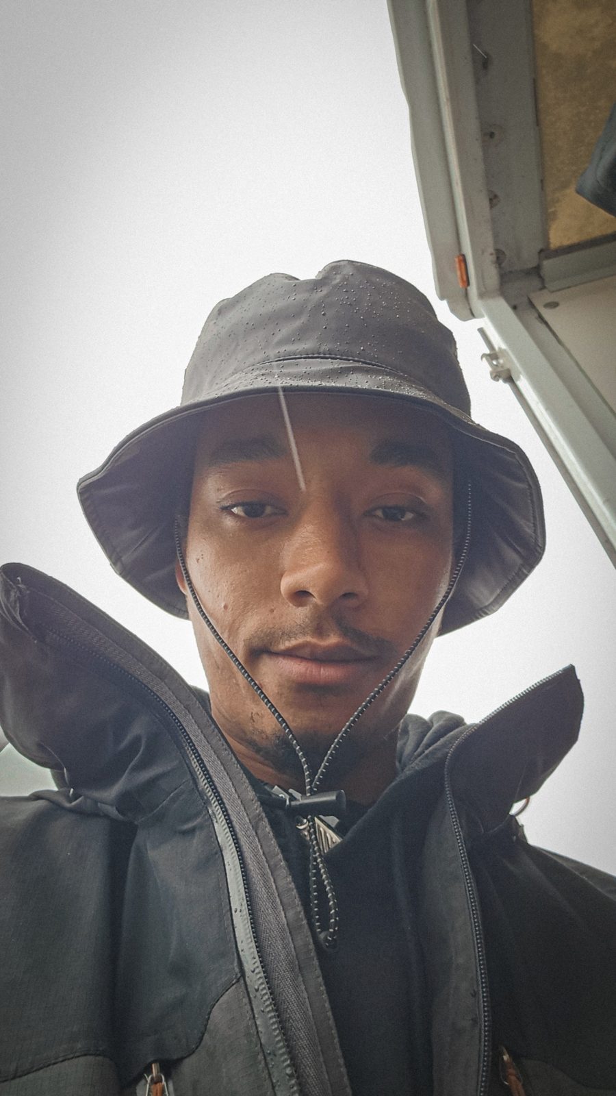 Issam in rain jacket and hat on a wet shoot day