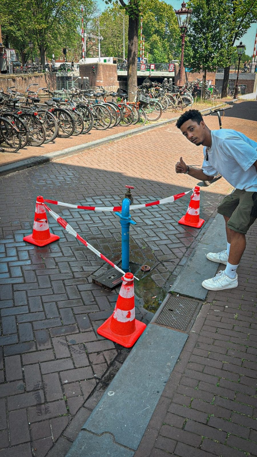 Issam gives a thumbs up next to a fenced-off hydrant