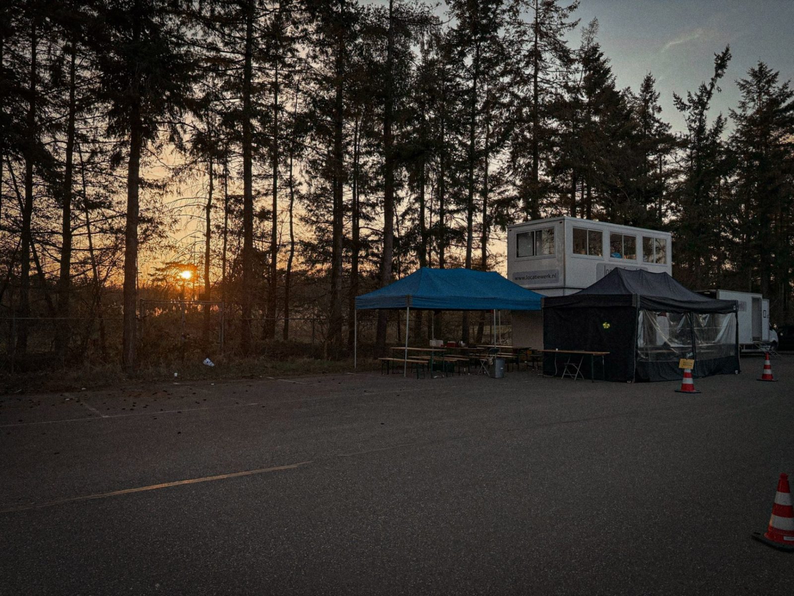 Tenten en een kantoorunit op de crewbase bij zonsondergang