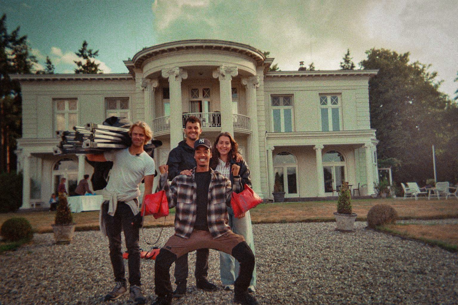 Crew posing in front of a white villa
