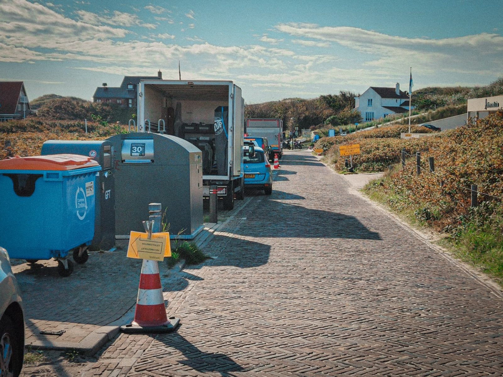 Bakwagen en pionnen langs een weg in de duinen
