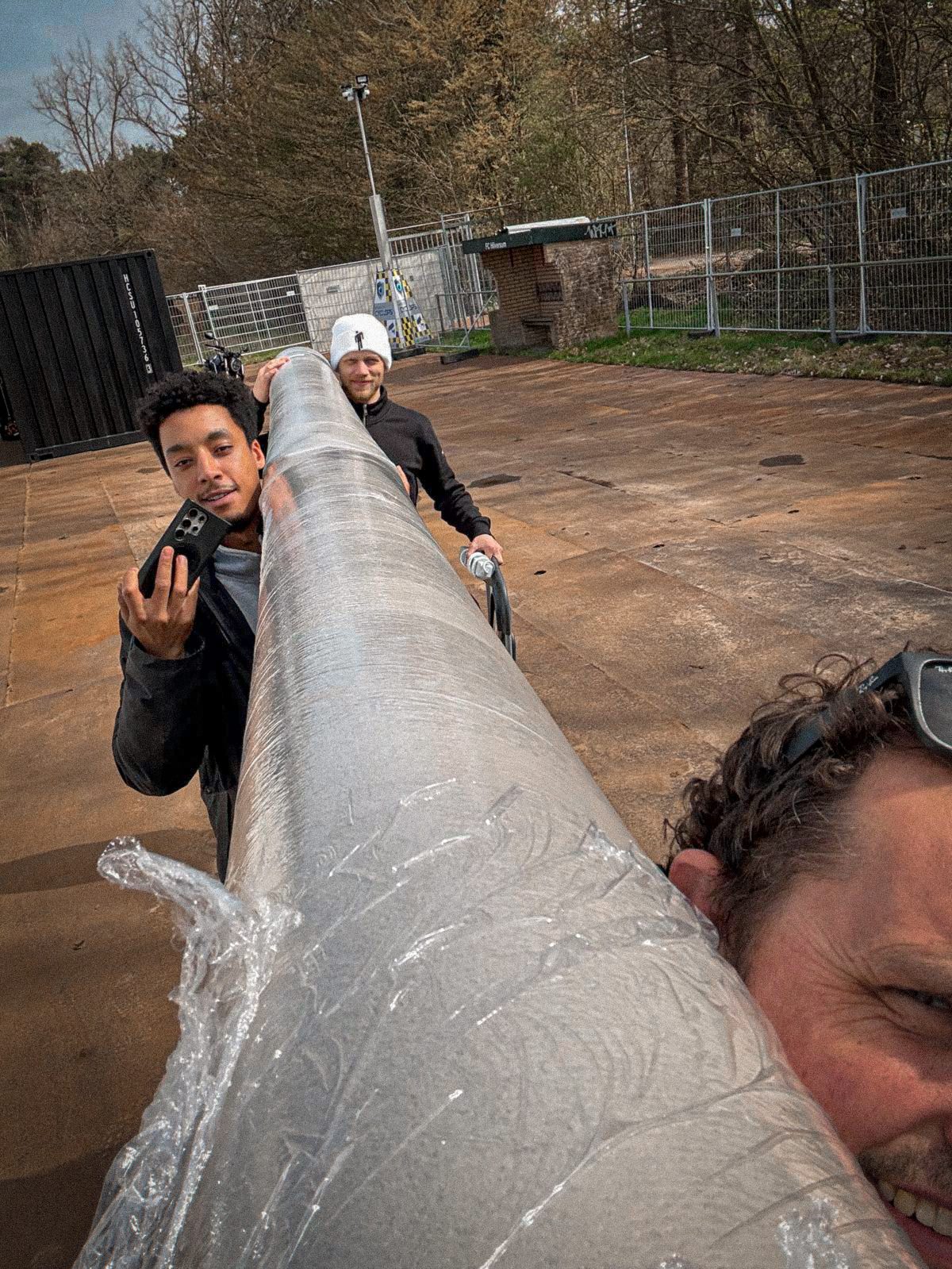 Issam and colleagues carrying a large cable tube together